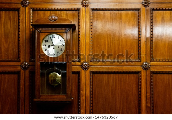 Grandfather clock in wooden case. wood Background.\
Pendulum wall\
clock.