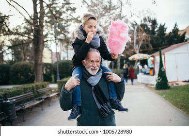 Grandfather enjoying with his grandson in city park.
