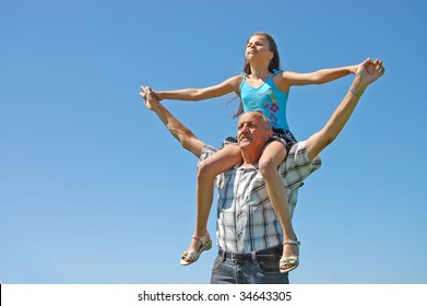 Grandfather With The Grand Daughter Against The Dark Blue Sky