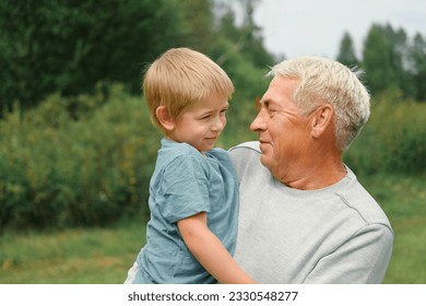 Grandfather and grandchild baby have fun during walk In Park. Happy family time. Old man grandpa hugging 4 years child boy at summer day. Smiling Senior male spending time with his grandson together. - Powered by Shutterstock