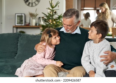 Grandfather and grandchildren bonding on sofa at Christmas time - Shutterstock ID 2209426587