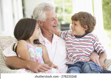 Grandfather And Grandchildren Relaxing In Chair