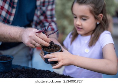 Grandfather and granddaughter carefully planting a seedling together, nurturing family bonds. - Powered by Shutterstock