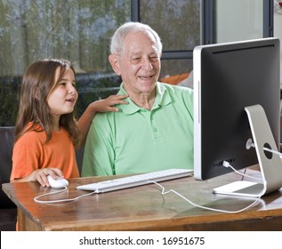 grandfather and granddaughter with computer at home - Powered by Shutterstock