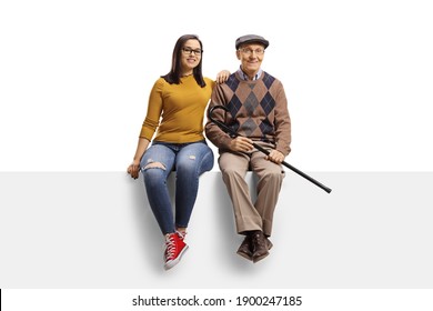 Grandfather And Granddaughter Sitting On A Blank Panel And Smiling At Camera Isolated On White Background