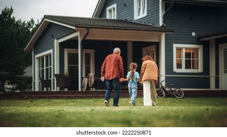 Grandfather and Grandmother Walking Together with Their Granddaughter in Front of their Suburbs House. Grandparents Spending the Weekend with Kids, Enjoying Family Time with Grandchild. - Powered by Shutterstock