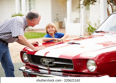 Grandfather And Grandson Cleaning Restored Classic Car