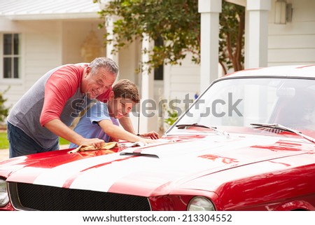 Grandfather And Grandson Cleaning Restored Classic Car