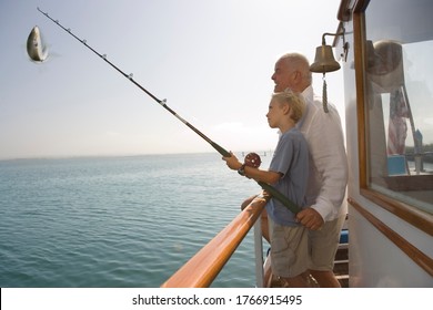 Grandfather And Grandson Fishing On Boat