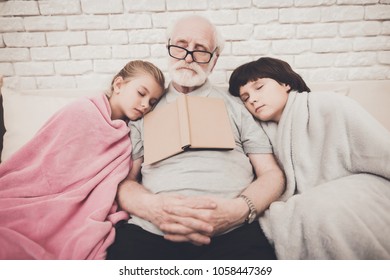 Grandfather, Grandson And Granddaughter On Sofa At Home. Grandpa And Children Are Sleeping.