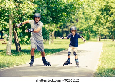 Grandfather and grandson having fun, roller skating in the park
