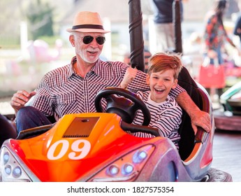 Grandfather And Grandson Hawe Fun In Bumper Car