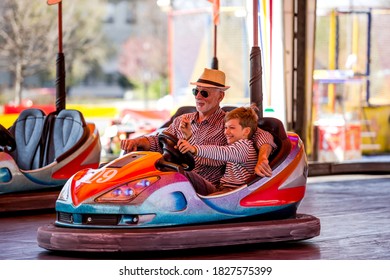 Grandfather and grandson hawe fun in bumper car