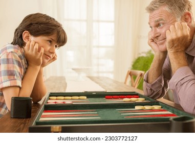 Grandfather and grandson playing backgammon
