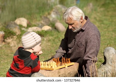 Grandfather And Grandson Playing Chess