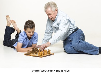 Grandfather And Grandson Are Playing Chess