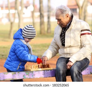 Grandfather And Grandson Playing Chess