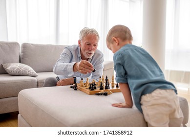 Grandfather And Grandson Playing Chess At Home