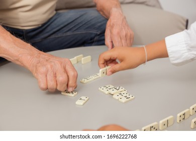 Grandfather And Grandson Playing Game Dominoes.