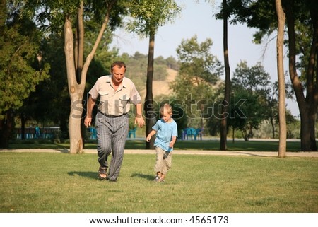 Grandfather with grandson run as to lawn