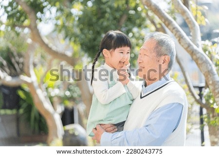 Grandfather and grandson smiling in the garden