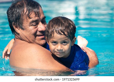 Grandfather and grandson taking a good moment in the pool together.
