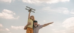 Grandfather And Grandson With Toy Plane Over Blue Sky And Clouds Background. Two Men Generation Grandfather And Grandson Playing Outdoors.