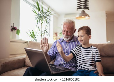 Grandfather and grandson using laptop together - Shutterstock ID 1216808182