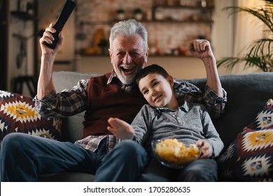Grandfather and grandson watching television. Grandfather and grandson enjoying at home.