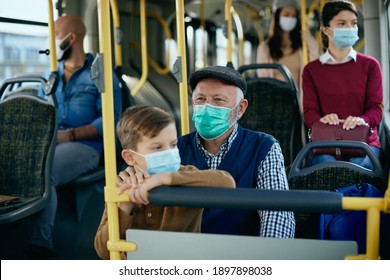 Grandfather And Grandson Wearing Protective Face Masks While Commuting By Bus. 