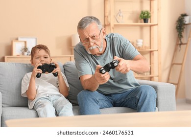 Grandfather with his cute little grandson playing video games at home - Powered by Shutterstock