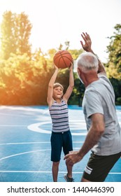 Grandfather And His Grandson Playing Basketball.