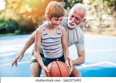 Grandfather And His Grandson Playing Basketball.