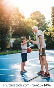 Grandfather And His Grandson Playing Basketball.