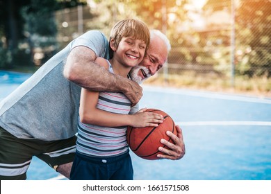 Grandfather And His Grandson Playing Basketball.