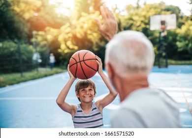 Grandfather And His Grandson Playing Basketball.