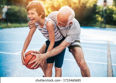 Grandfather And His Grandson Playing Basketball.