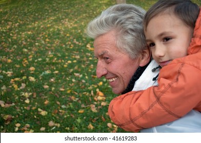 Grandfather Holding Grandson On His Back