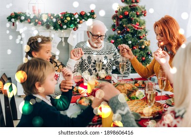 grandfather holding hands during prayer with family, bokeh lights illustration - Powered by Shutterstock