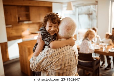 Grandfather hugging his grandson in the living room - Powered by Shutterstock