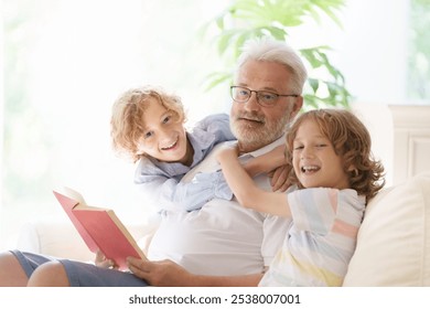 Grandfather and kids read book at home. Happy on white couch. Grandpa and children reading. Generation love. Retired senior man with little boy. Grandchildren visit grandparents. - Powered by Shutterstock