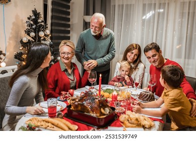 Grandfather is making a toast at the table. Family celebrating Christmas together eating homemade food. - Powered by Shutterstock