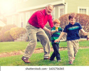 Grandfather Playing And Chasing Grandsons Outside