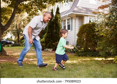 Grandfather Playing In Garden With Grandson
