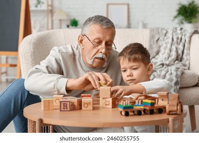 Grandfather playing with his cute little grandson at home - Powered by Shutterstock