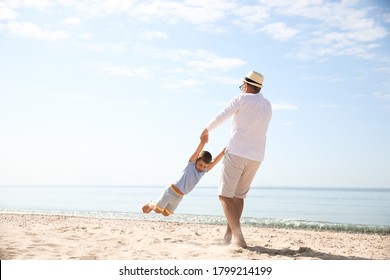 Grandfather playing with little boy on sea beach - Powered by Shutterstock