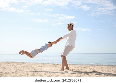 Grandfather playing with little boy on sea beach - Powered by Shutterstock