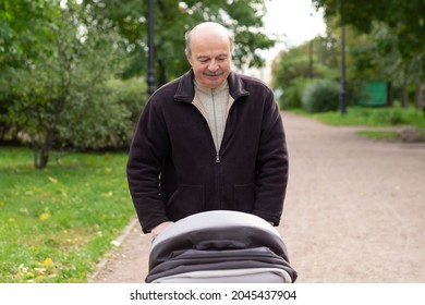 Grandfather Pushing Newborn In Stroller In Park