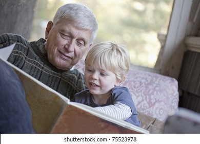 Grandfather Reading A Book To His Grandchild