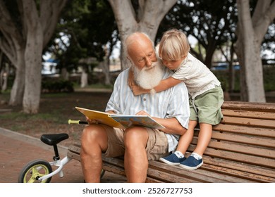 Grandfather Reading a Storybook to His Grandson on a Park Bench - Powered by Shutterstock